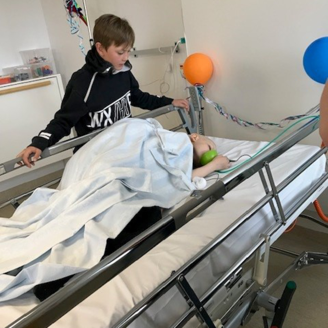 Tim står bredvid sjukhussängen där Vilgot ligger med syrgasmask.