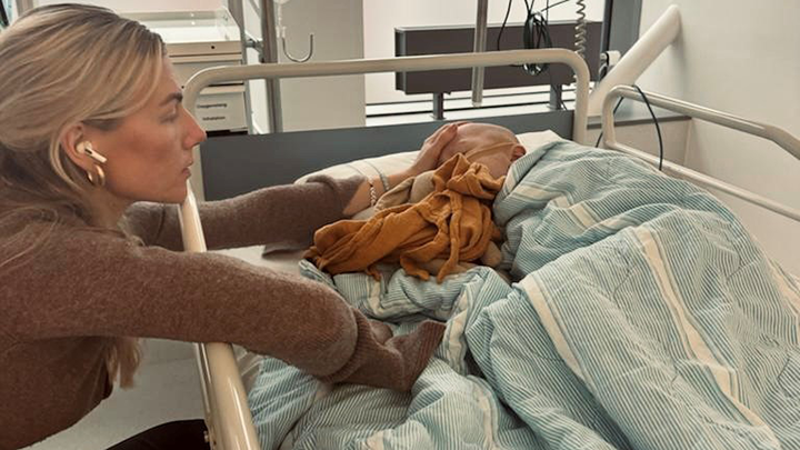 Mamma Ellinor sitter med Tage vid sjukhussängen