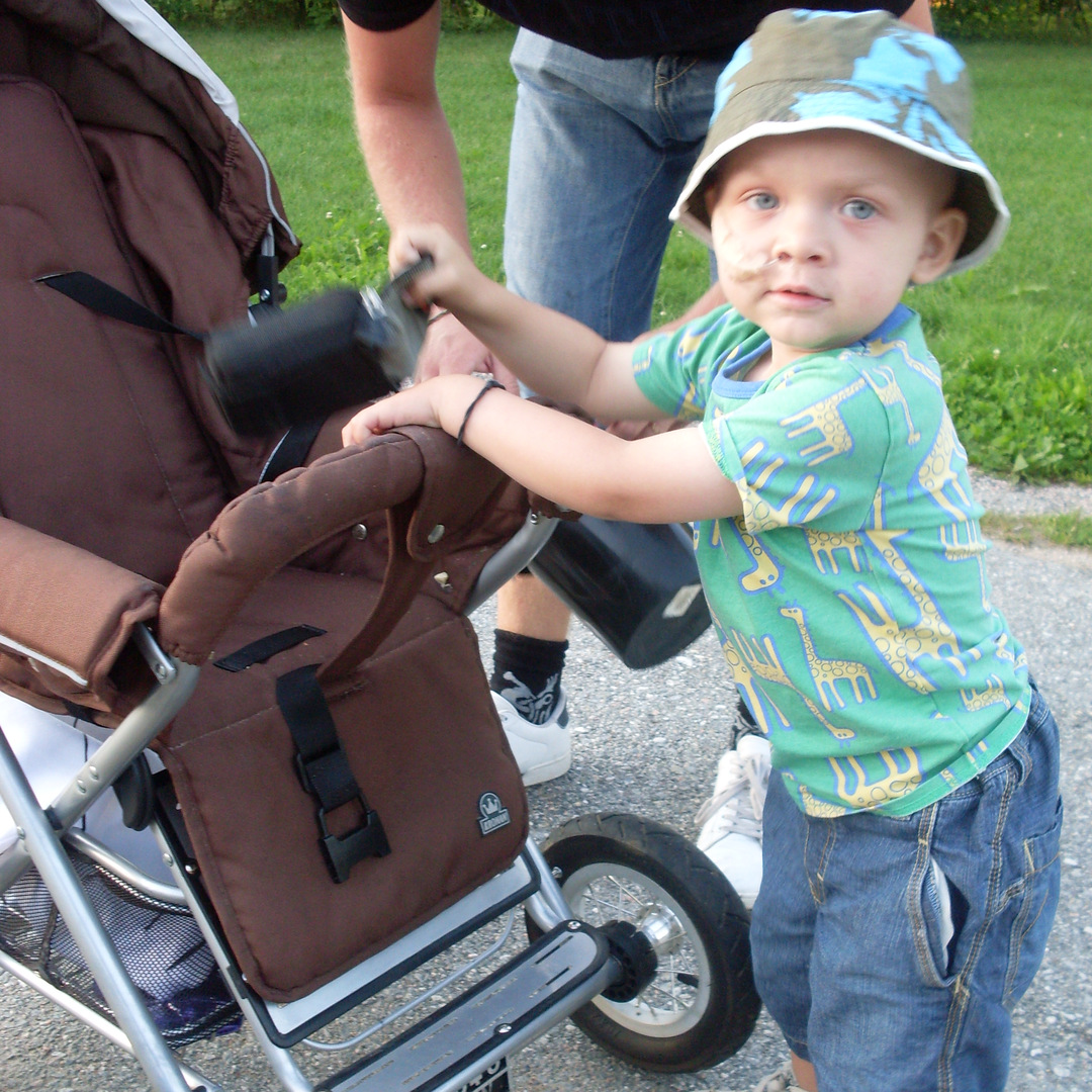 Noel står och håller i sin vagn, foto.