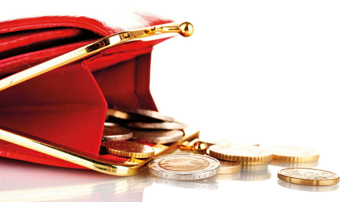 En öppen portmonnä med några mynt på bordet. 