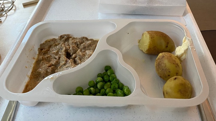 Plastlåda med kött med brunsås, potatis och ärter.