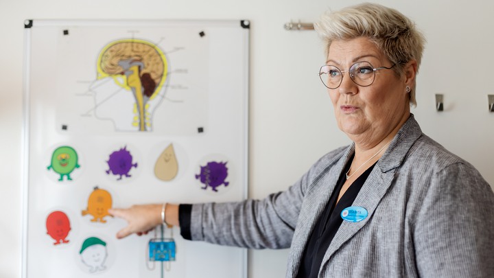 Kvinna som visar se-höra-göra materialet