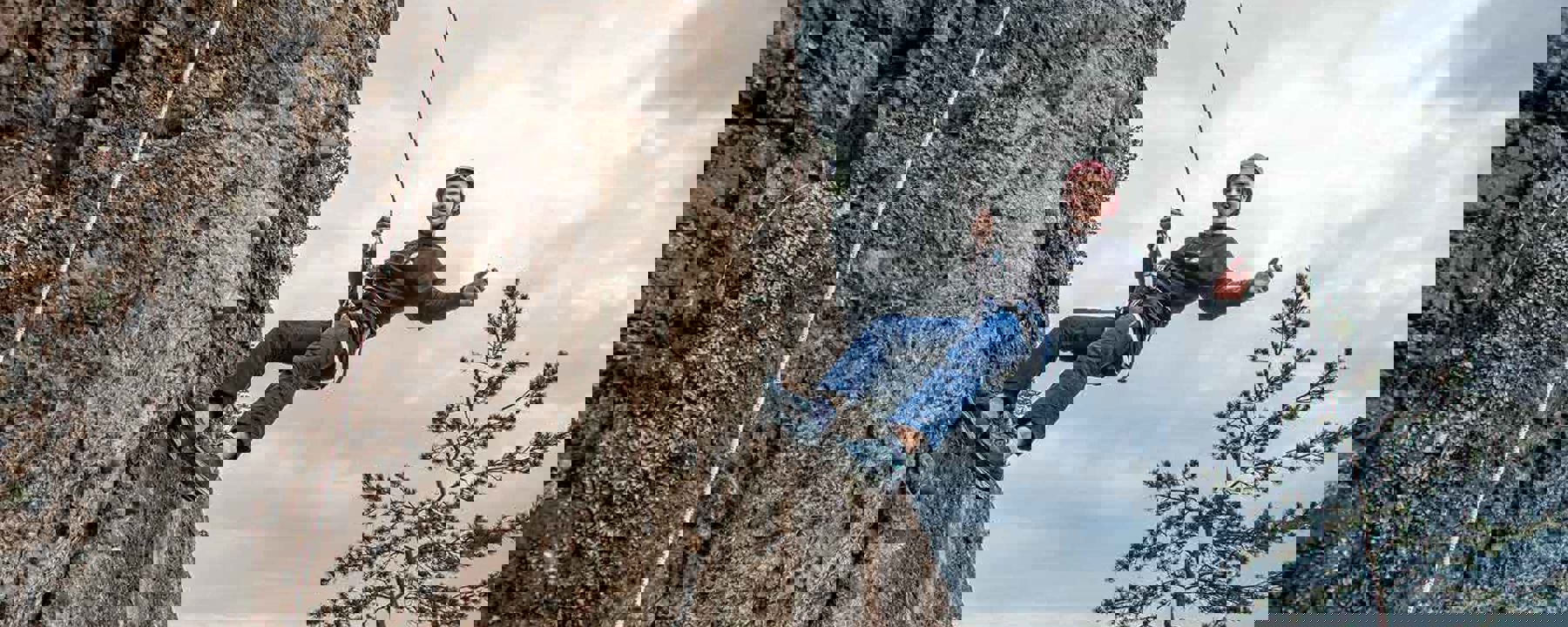 Pojke klättrar på bergsvägg