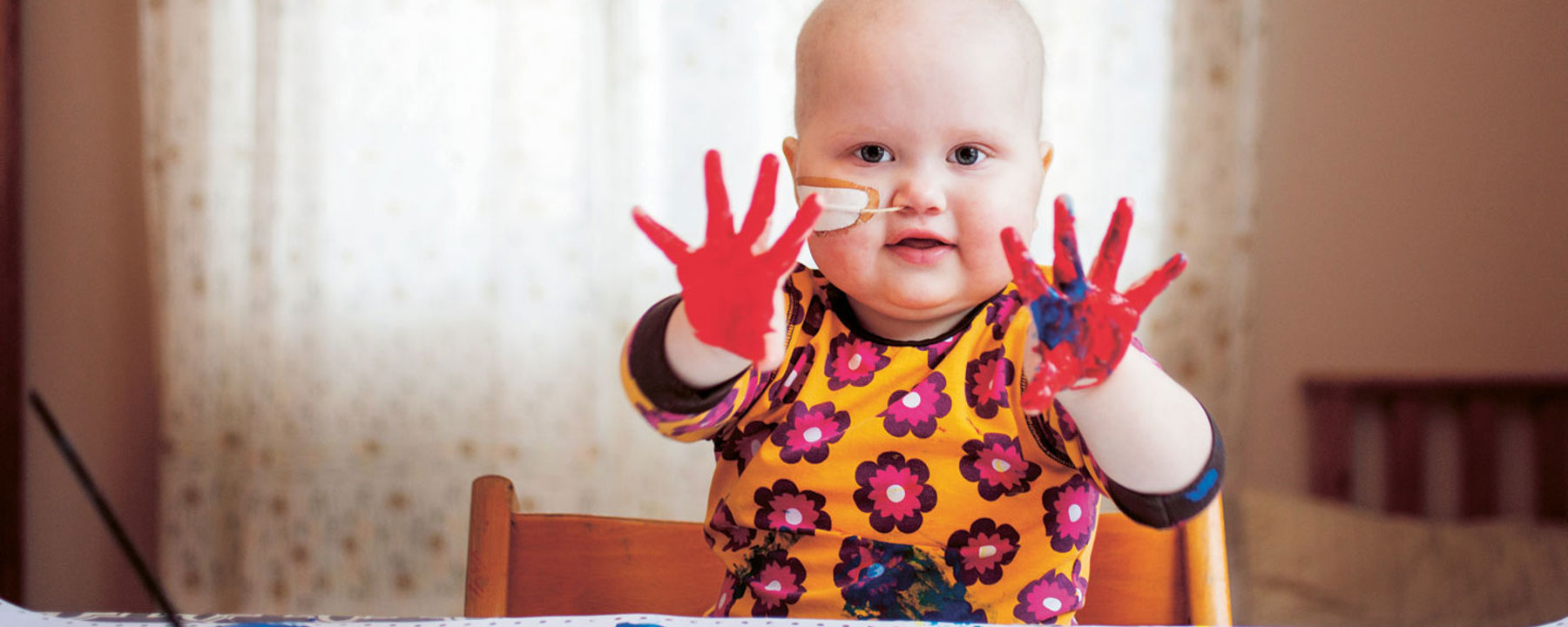 Hillevi fingermålar och visar upp båda sina händer, täckta med färg.