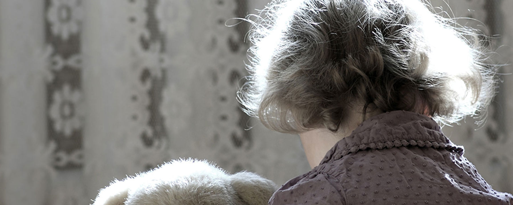 Ett barn och en nalle bakifrån.