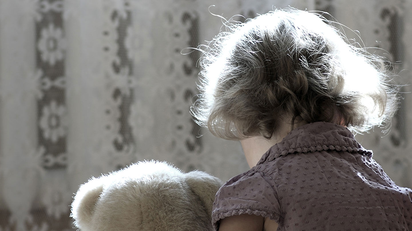 Ett barn och en nalle bakifrån.