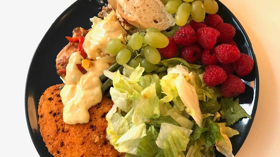 Mattallrik med kycklingschnitzel, sås, sallad, bröd, vindruvor och hallon