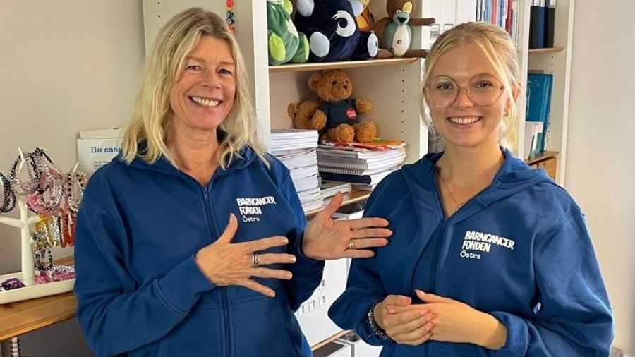 Inca pekar på Jennifer. Blå tröjor med Östralogga. Halvkroppsbild.