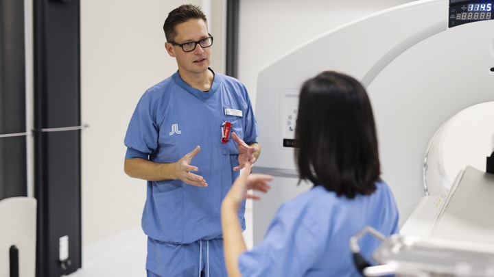 En man i operationskläder pratar med en kvinna i operationskläder