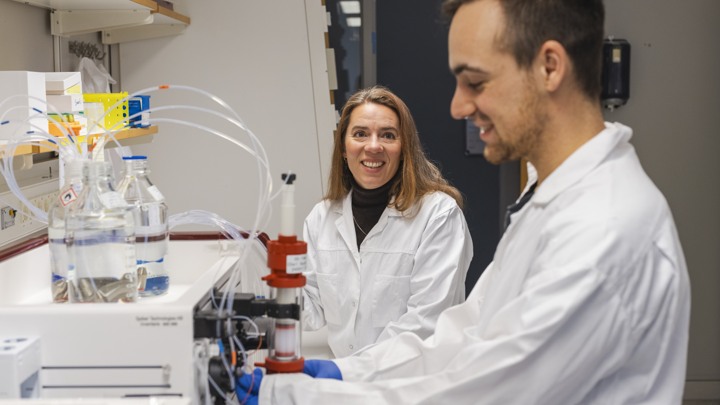 En man och en kvinna i labbrockar arbetar tillsammans